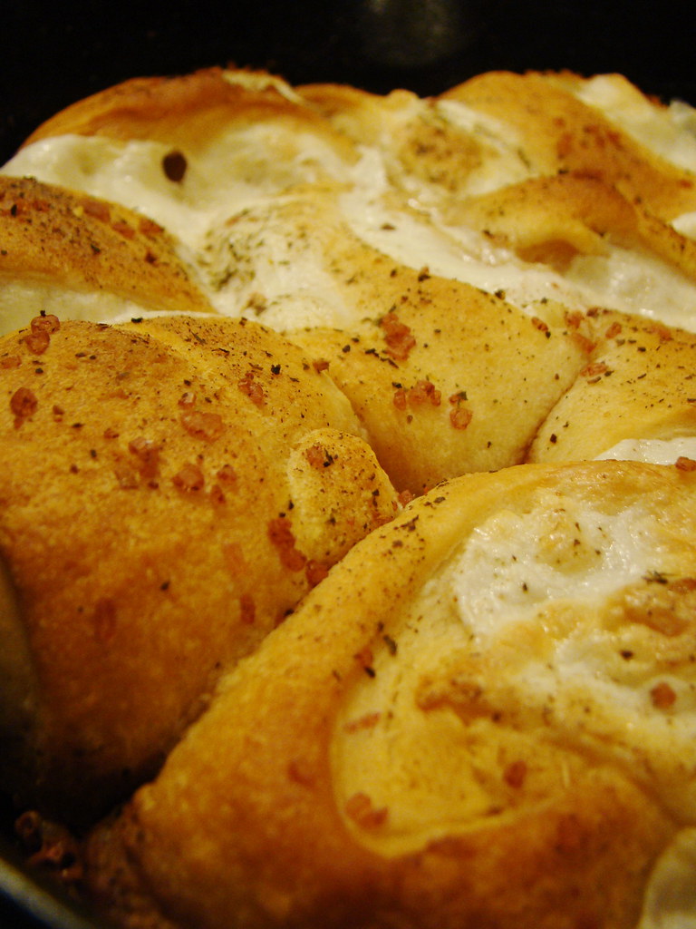 Pie dough being rolled out on a floured surface with visible flecks of cold butter