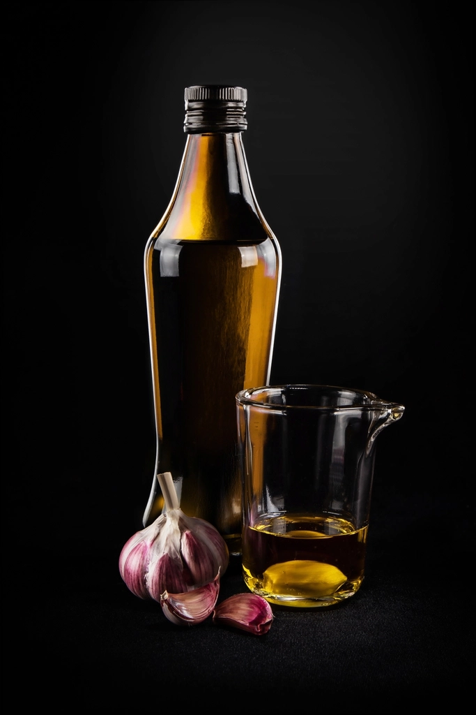 Several bottles of different cooking oils, including olive oil and avocado oil, lined up on a countertop.