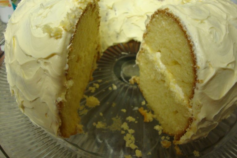 Sliced layer cake on a cake stand showing a moist, tender crumb
