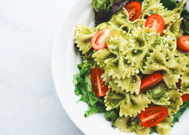 Green pasta served with tomatoes and fresh herbs.