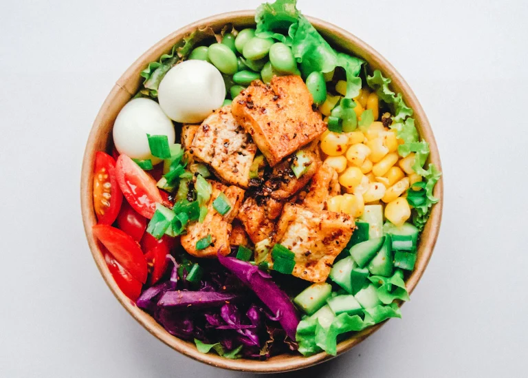 Crispy tofu and colorful vegetables arranged in a bowl.