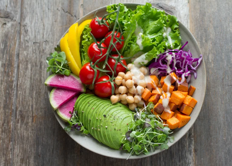 A grain bowl with avocado, chickpeas, tomatoes and greens.