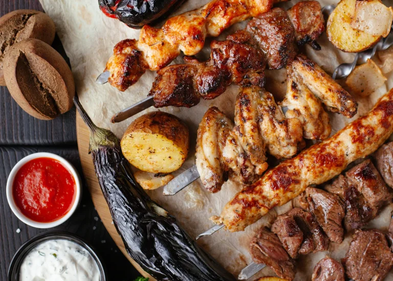 Grilled chicken pieces served with golden potatoes and vegetables.