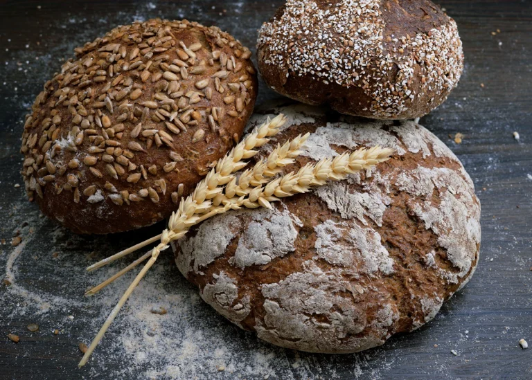 A round rustic bread loaf on a wooden surface.